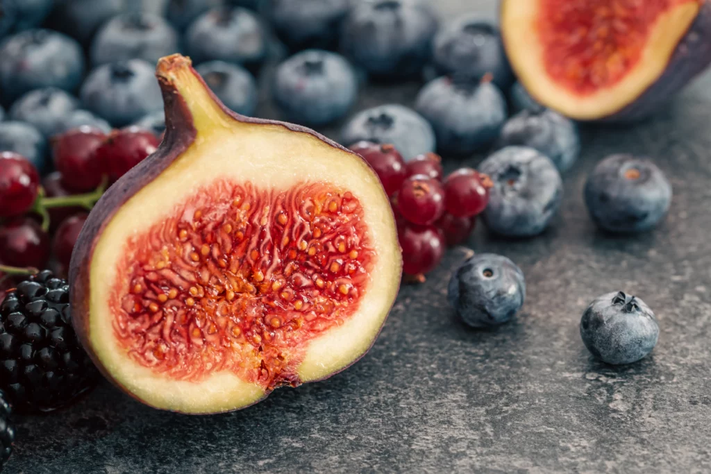 Reife Feigen im Schnitt und Beeren in Großaufnahme, Hintergrund mit Beeren von food fotograf hannover