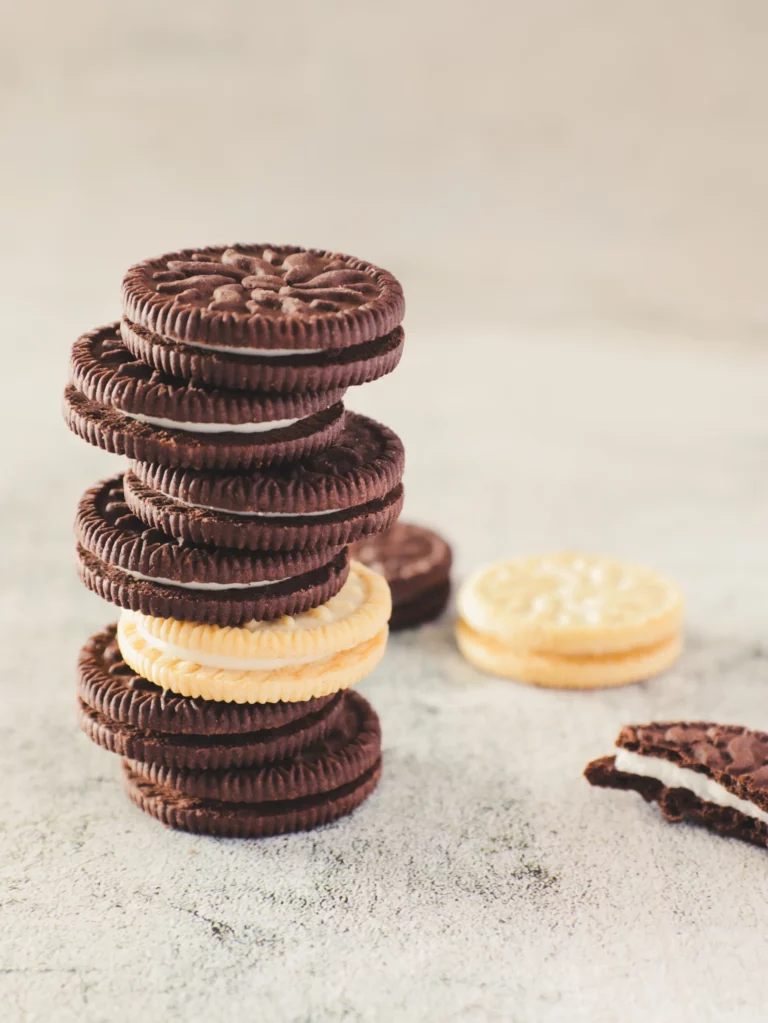 Ein Stapel Oreo-Kekse mit einem Vanille-Sandwich-Keks in der Mitte und einem angebissenen Keks daneben aufgenommen mit 85mm Brennweite von Food Fotograf Hannover.