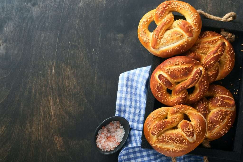 Bavarian pretzels and glass of lager beer. Oktoberfest food menu, traditional salted pretzels over o