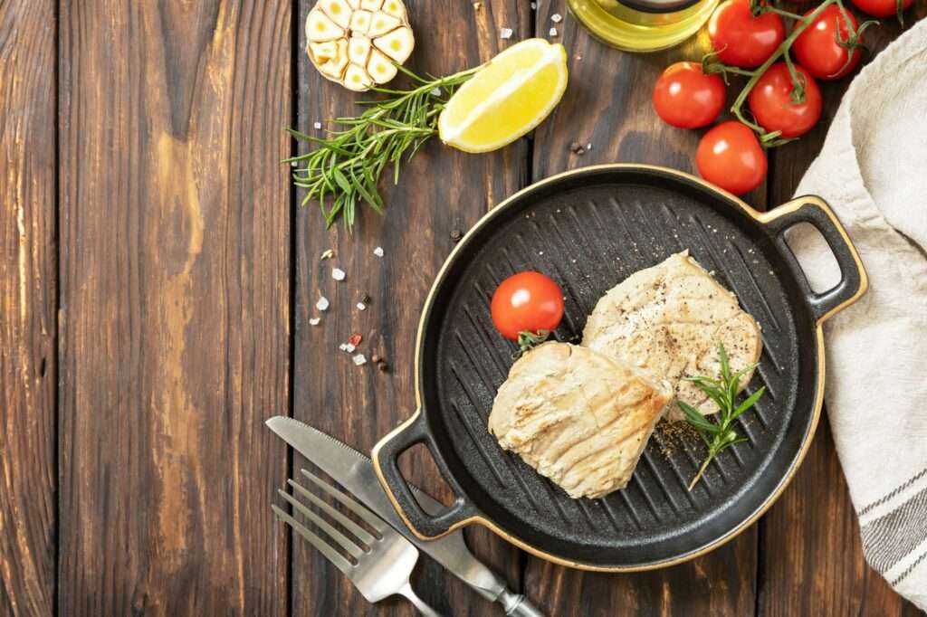 Restaurant food. Seafood. Rustic style. Cooked juicy tuna steak with spices, tomatoes.